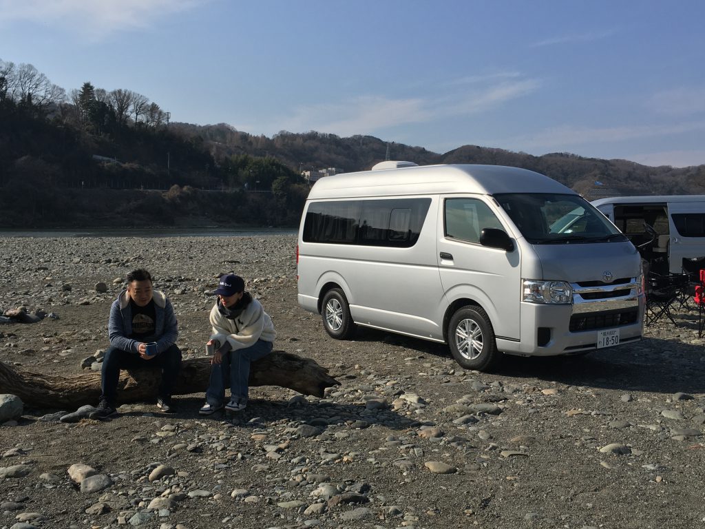 シーン1:河原での撮影。流木で談笑する男女モデル。